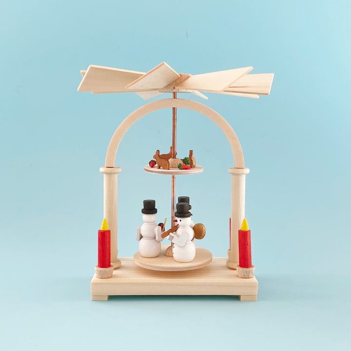 Small traditional wooden candle pyramid from Germany. Features two central tiers, one with a snowman band, and a smaller one with rabbits and carrots.