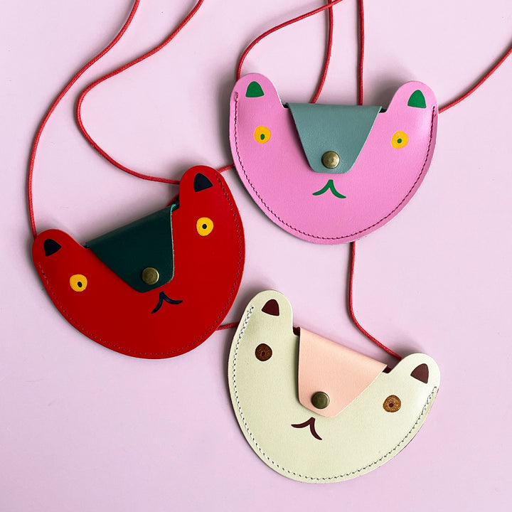 Three colorful bear purses on light pink background.