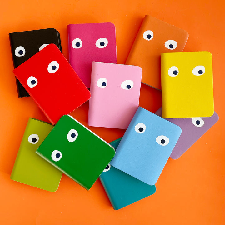Several small colorful notebooks with orange background.
