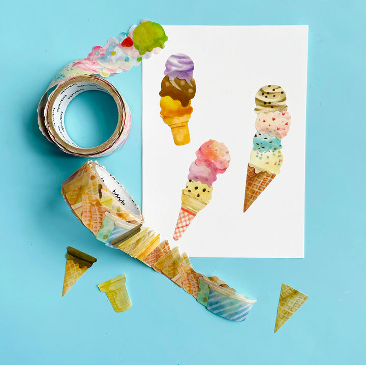 Two rolls of washi tape stickers (one with ice cream scoops and one with ice cream cones) displayed on a light blue background. The stickers have been used to make a picture of three ice cream cones with multiple scoops.