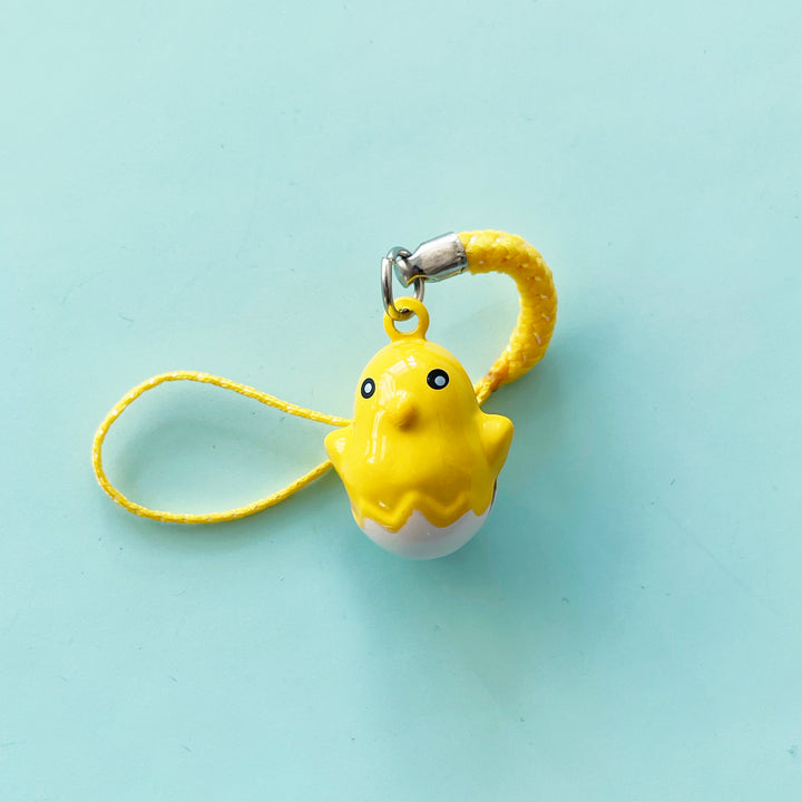 A very small chick-in-egg shaped bell with a loop attached to the top.
