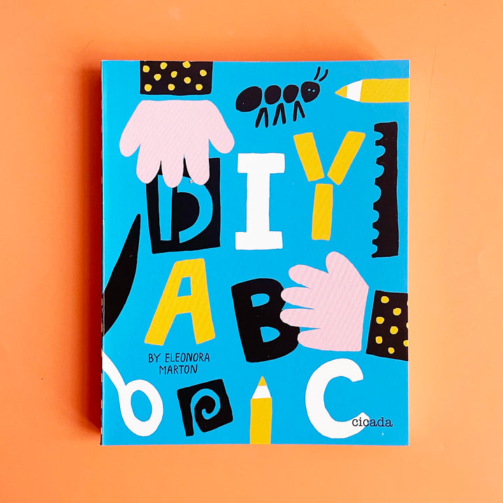 A copy of the book "DIY ABC". The cover features a colorful cut out design featuring  the title, hands, some scissors and an ant.