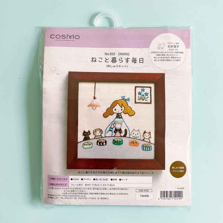 Packaged embroidery kit featuring an image of a girl with her 5 pet cats sitting at a table ready to eat.