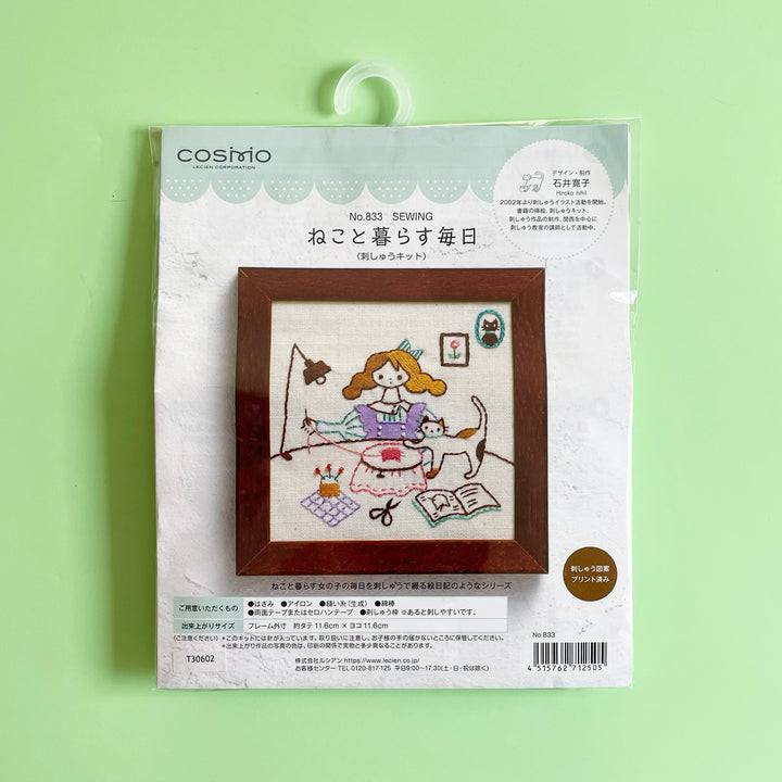 Packaged embroidery kit featuring an image of a girls and a sewing table working on an embroidery project with her playful cat.