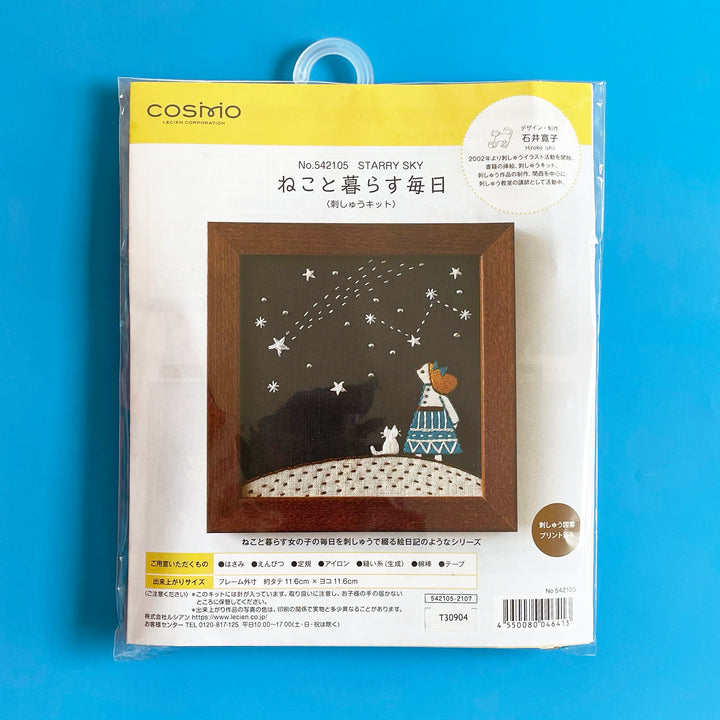 Packaged embroidery kit featuring a girl stargazing with her mall white cat.