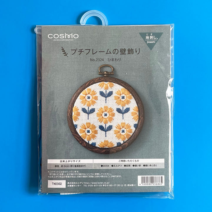 Pavckaged embroidery kit featuring pattern of bold sunflowers in yellow and blue.