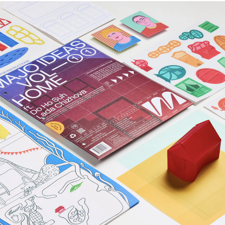 Contents from Majo Ideas Home Activity kit laid out. Includes a 3D paper house and coloring sheet.
