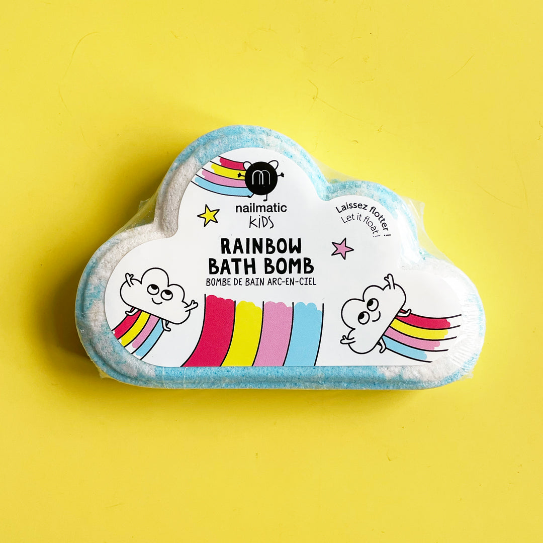 Rainbow bath bomb from French Brand Nailmatic on a bright yellow background.