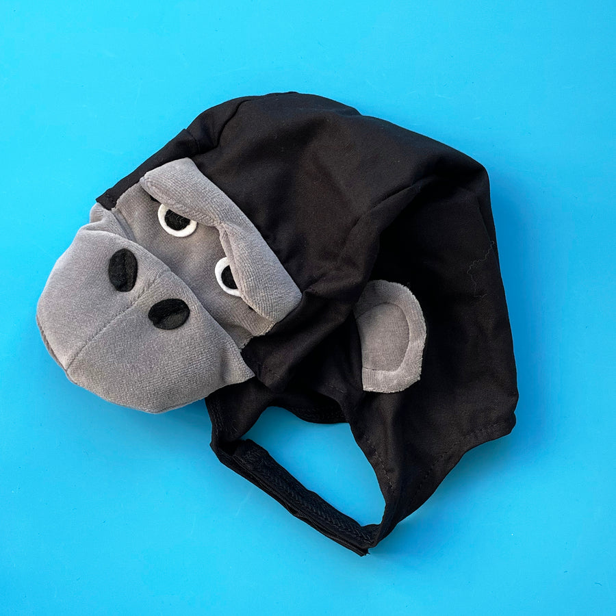 Black cotton gorilla costume hat with grey cotton-velour face , snout and ears. Displayed on a bright blue background.
