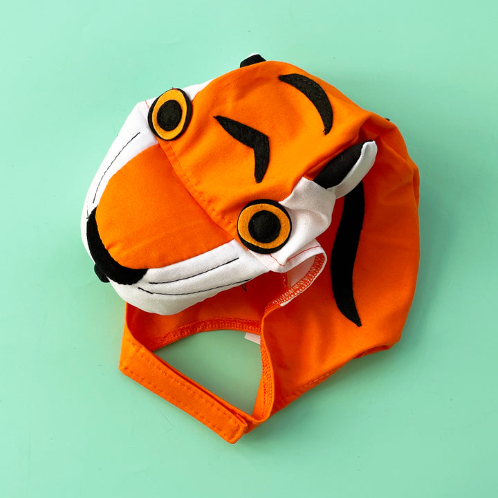 Bright orange cotton tiger costume hat with a stuffed snout and felt eyes.  Displayed on a light green background.