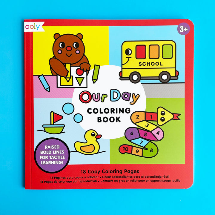 Our Day Coloring Book by Ooly displayed on a bright blue ackground. The book cover features bold drawings of a bear, a school bus, a duck and a snake.