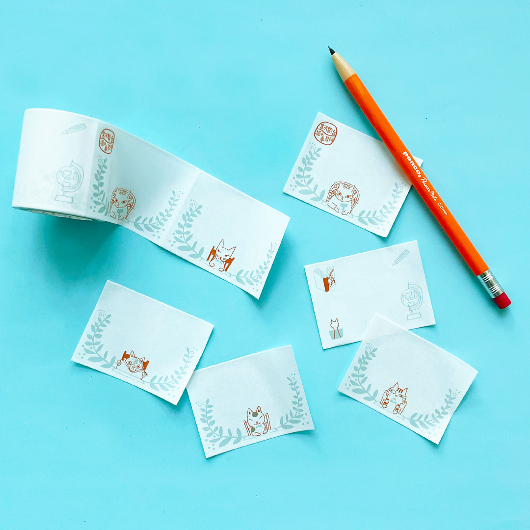 Several washi tape labels with cats on them on a blue background.