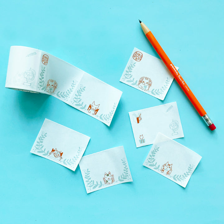 Several washi tape labels with cats on them on a blue background.