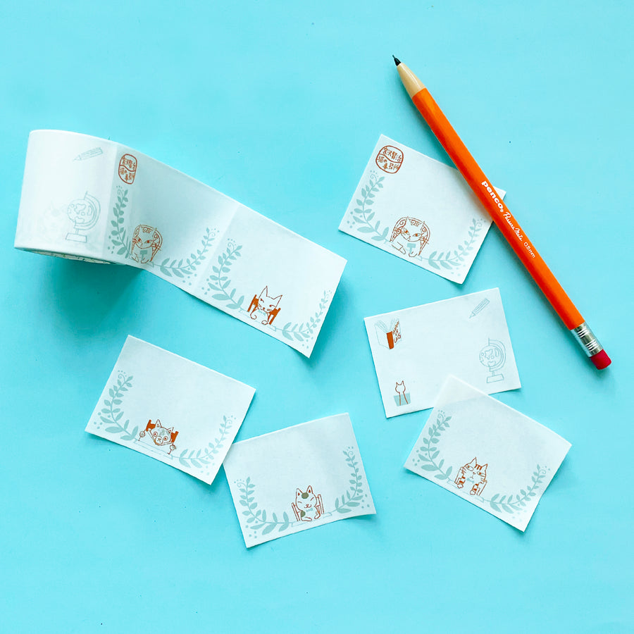 Several washi tape labels with cats on them on a blue background.