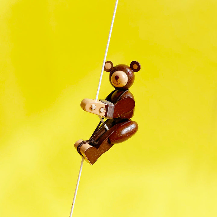 Bear shaped wooden figurine on a yellow background.