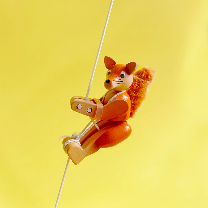 Fox shaped wooden figurine on a yellow background.