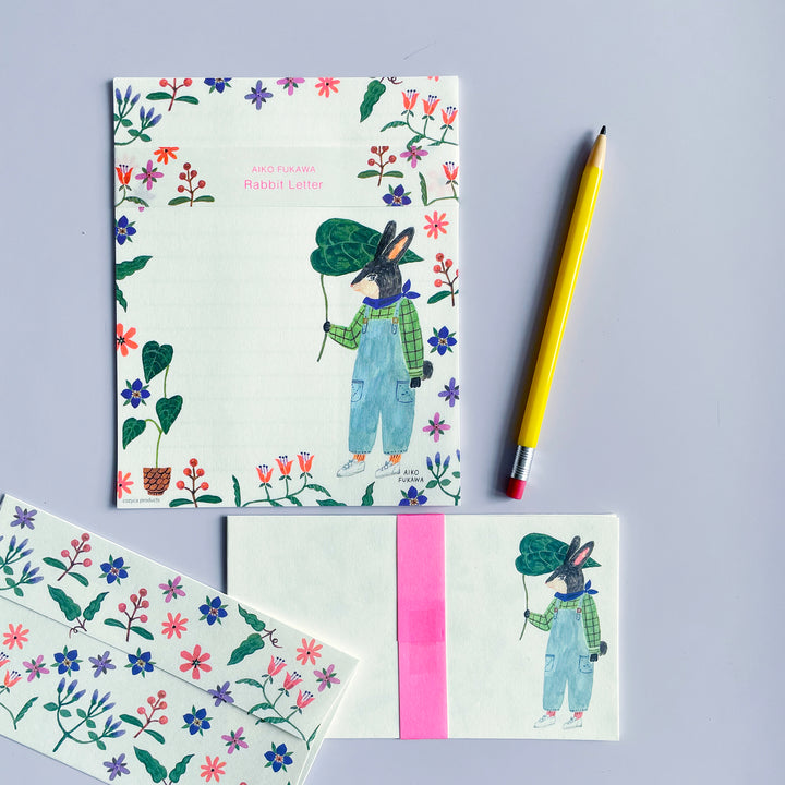 A stationary set illustrated with flowers and a rabbit. A yellow pencil lays on the right.