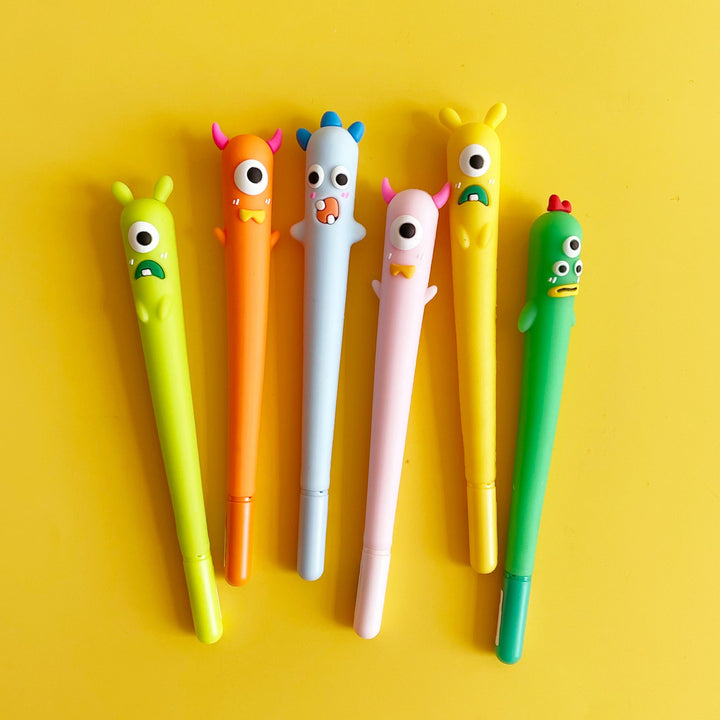 Six colorful monster shaped gel pens on a yellow background