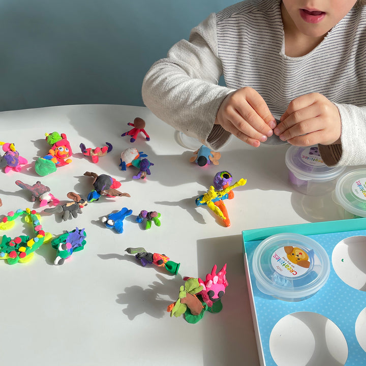 A child makes various sculptures out of multi-colored clay.