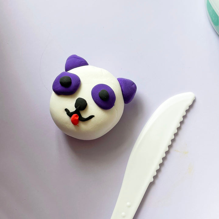 A purple and white panda made from clay.
