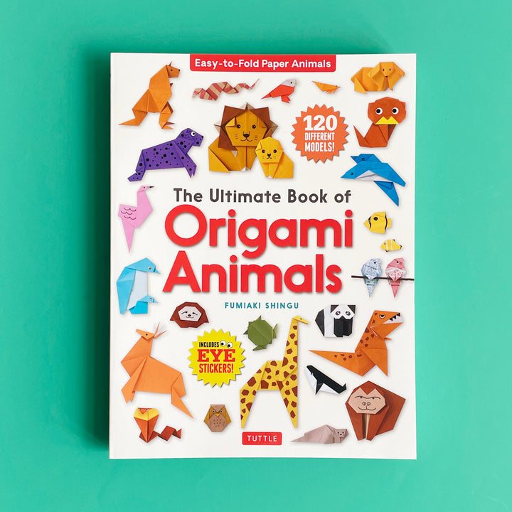 Origami Animals book displayed on a bright green background. The book cover features many animal origami projects including lions, a giraffe, a gorilla, penguins, parakeets and dogs.