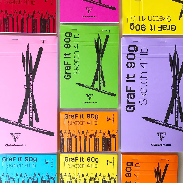 Several brightly colored sketch pads laying flat