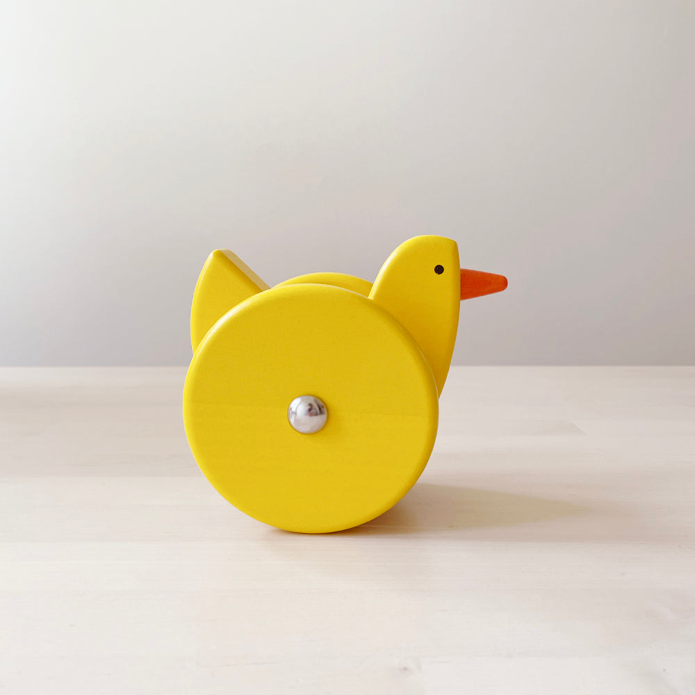 Wooden rolling toy in the shape of a yellow chicken