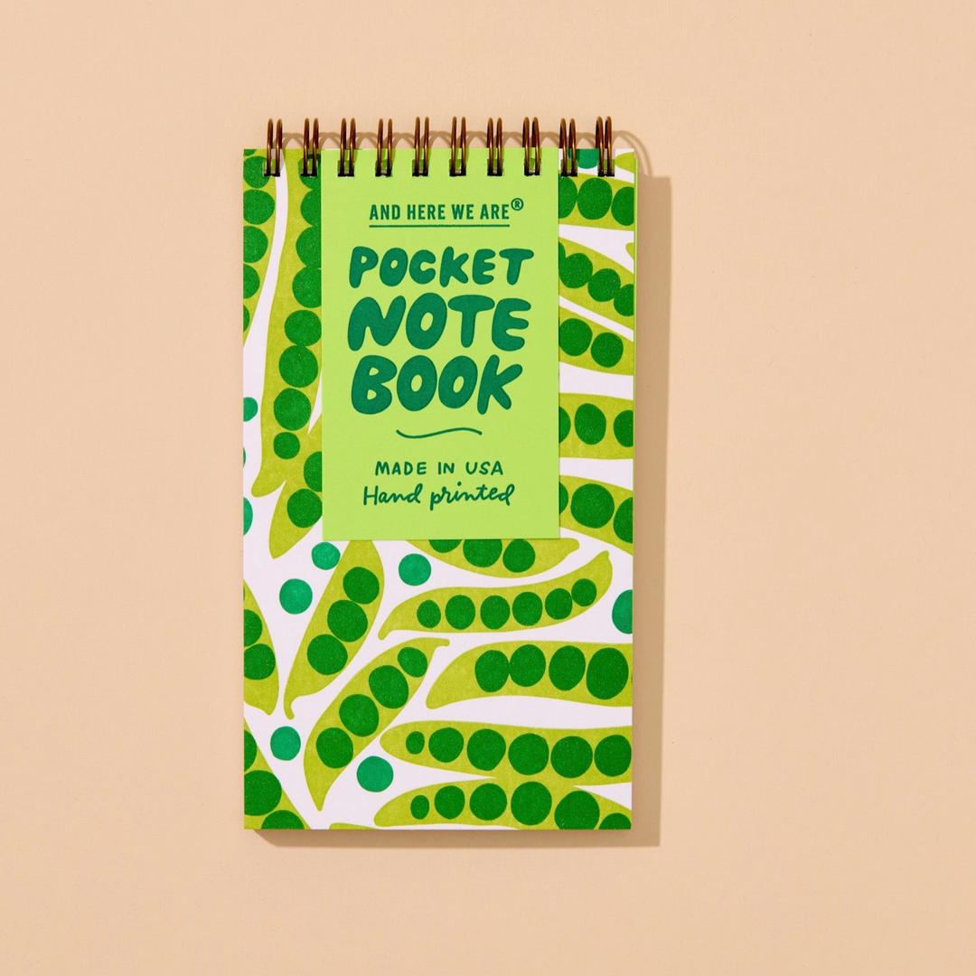 Pocket notebook with green and white design on a beige background