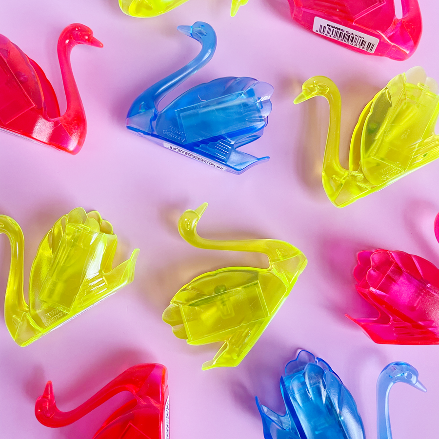 Colorful swan-shaped pencil sharpeners
 on a pink background