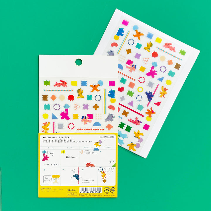 Colorful schedule sticker sheets with packaging on a green background