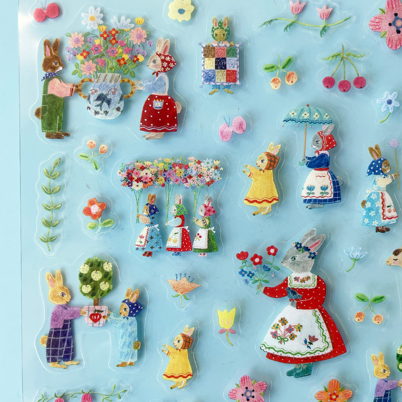Most of the stickers are of different colored rabbits in floral aprons and bonnets, holding beautiful objects like flowers, potted plants, umbrellas, and a quilt.