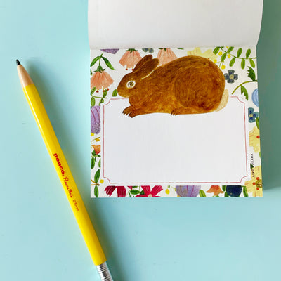 This page of the memo pad has a white writing area on a white background with flowers. A brown rabbit is illustrated above the writing area.