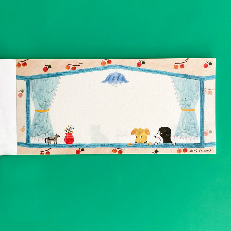 This page of the memo pad shows two dogs peeking into a blue-silled window. The window is surrounded by a blue light, blue curtains, and fruit-patterned wallpaper.