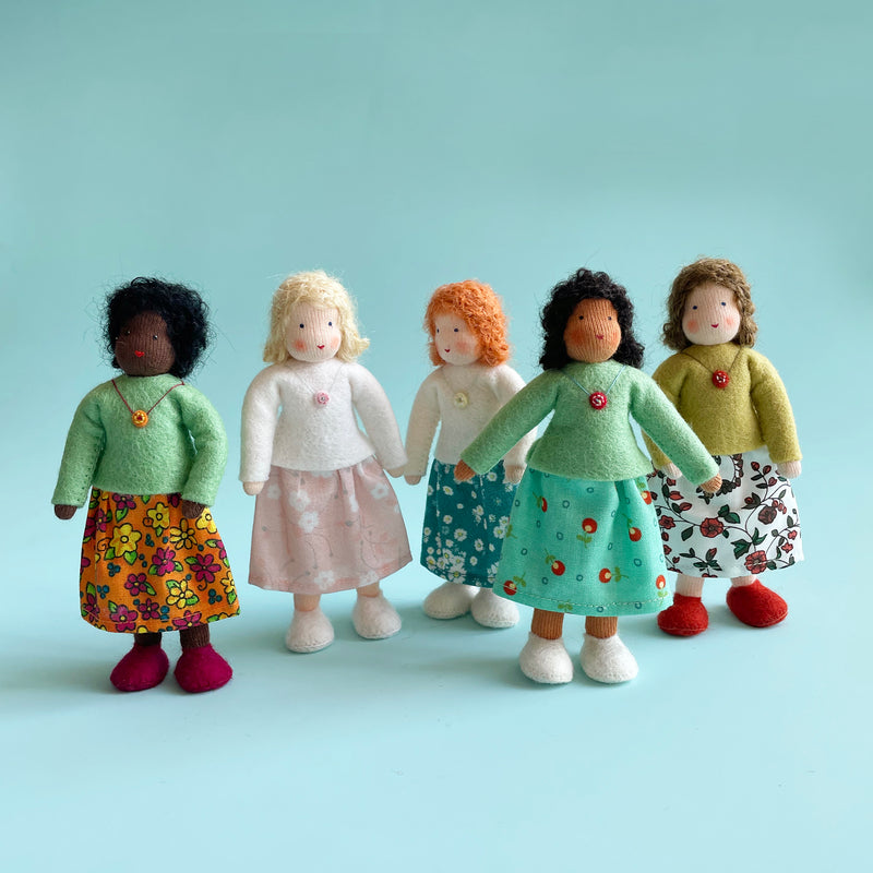 Five cotton dolls stand 5 inches tall, with various skin and hair tones, different colored felt tops, and various floral fabric skirts.