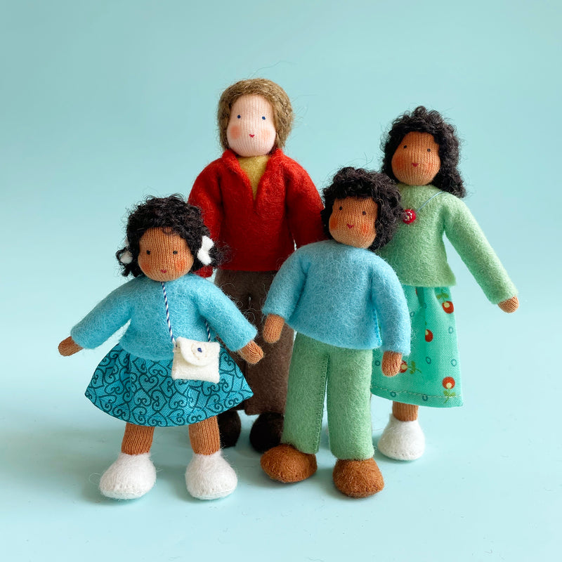 Four cotton dolls of various heights. Two dolls wear a skirt and top, and two dolls wear pants and a top.