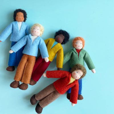 Five 5.25-inch cotton dolls lay on a blue background. The dolls have various skin colors, hair colors, and outfit colors.