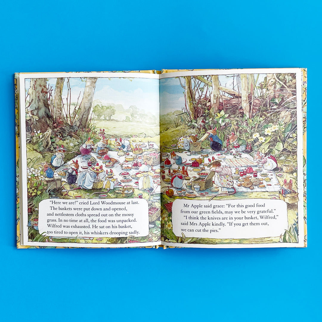 Open book with illustrations of animals at a picnic on a blue background