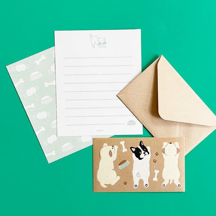Stationery set with a letter, envelope, and card featuring dog illustrations on a green background.