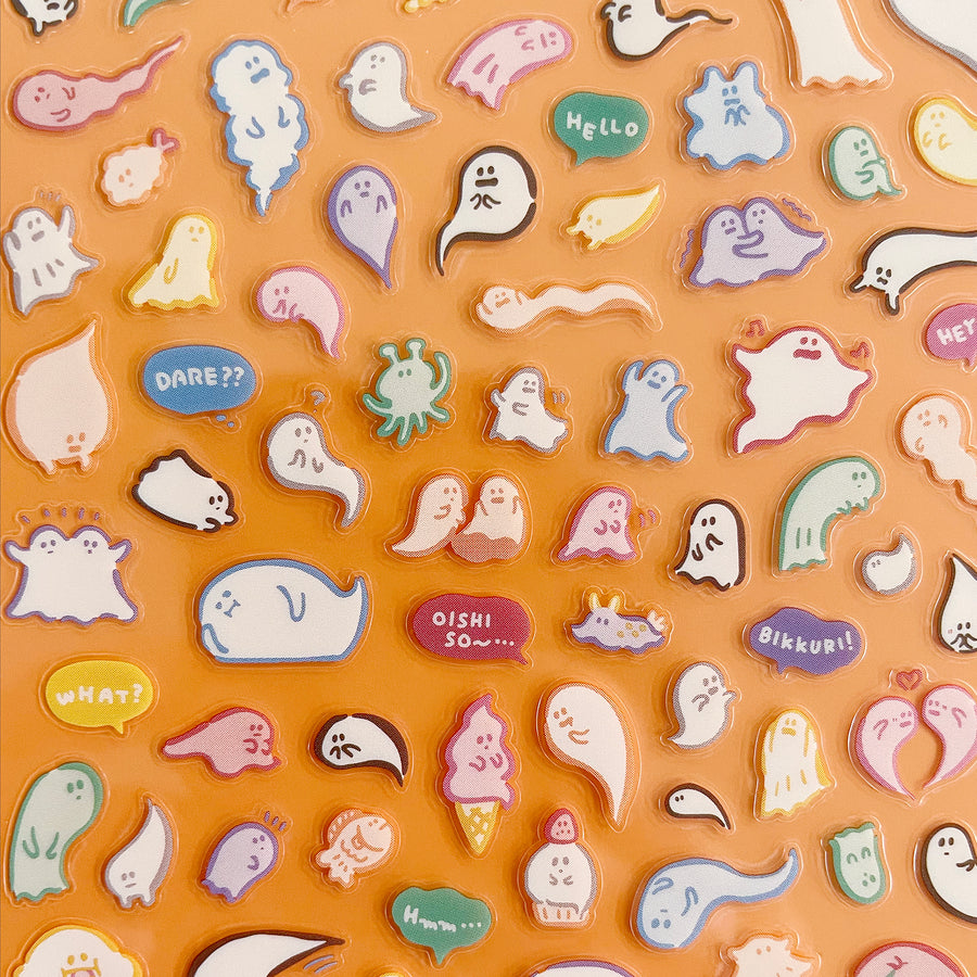Collection of colorful ghost-shaped stickers with various expressions and text on an orange background