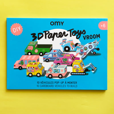 The packaging of the 3d paper car kit showing 3d paper vehicles illustrated with animals. The package says "OMY DIY 3D Paper Toys; Vroom; 10 Cardboard vehicles to build."