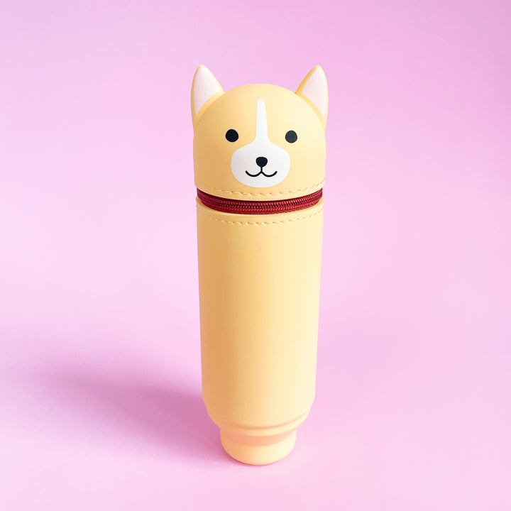 Yellow cylindrical pouch with dog face design on a pink background