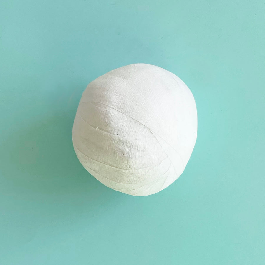 One small white surprise ball on a light blue bacground. 