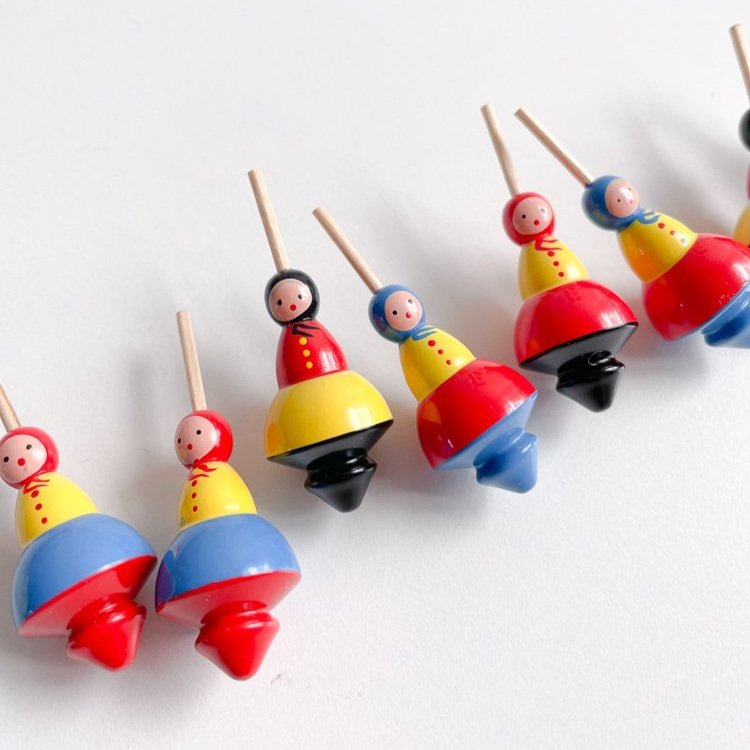 Seven small babushka lady shaped tops in a diagonal line. 