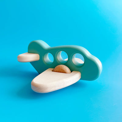 A simple wooden toy airplane, with a blue painted body and unpainted wooden wings.