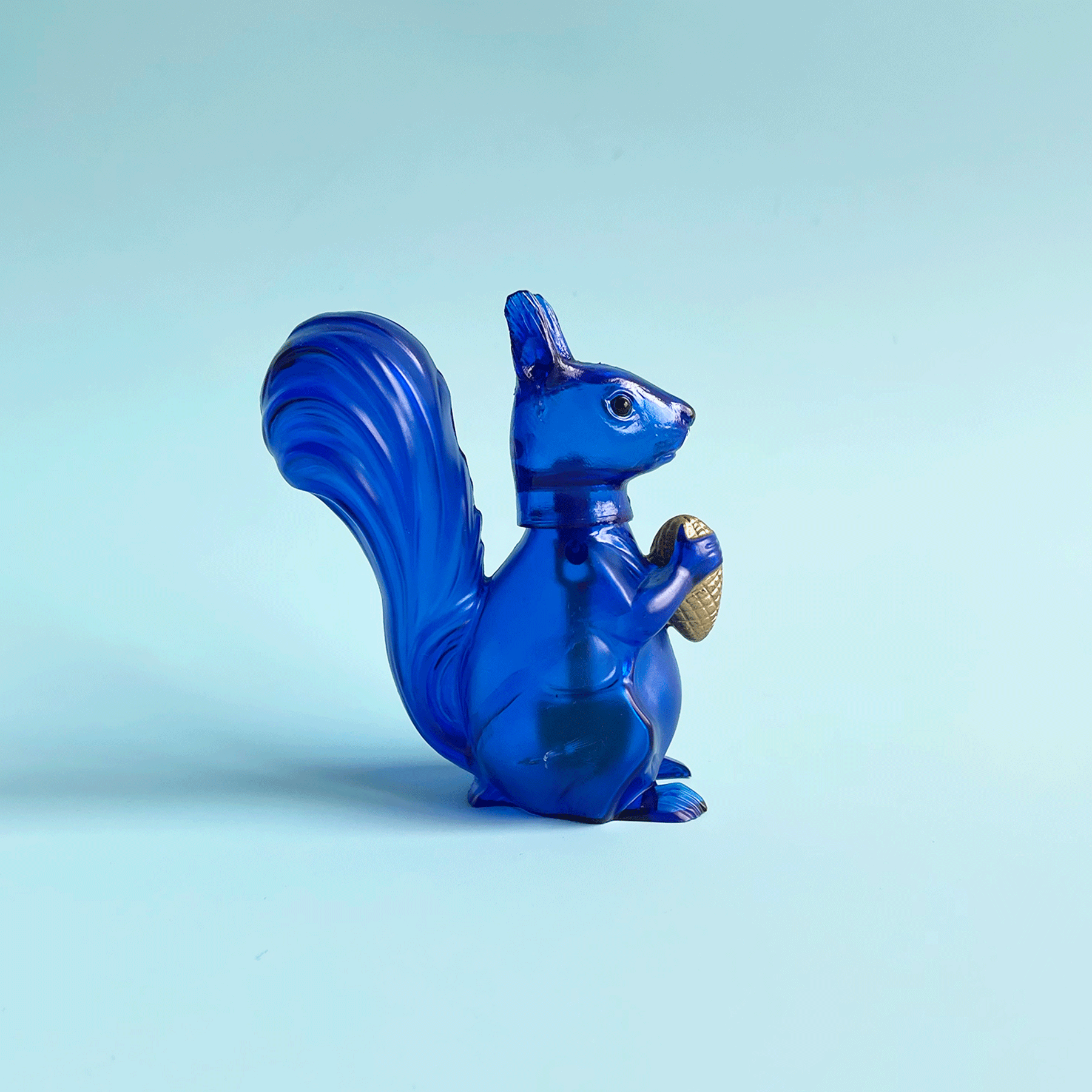 Translucent blue squirrel bobblehead figurine bobbing it's head back and forth. 