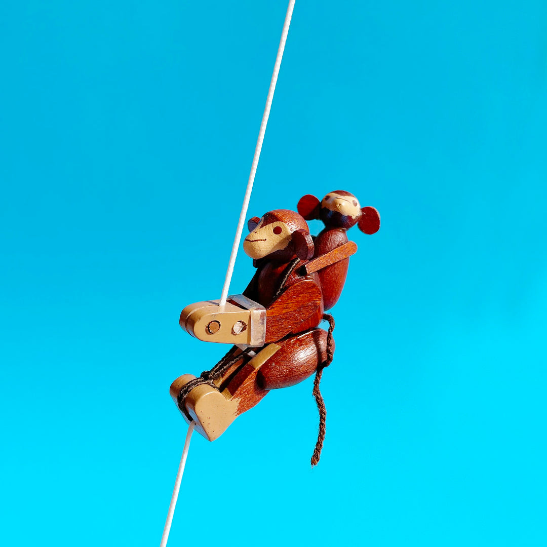 Monkey shaped wooden figurine on a blue background. 