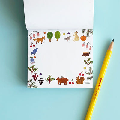 This page of the memo pad has white paper with a border of woodland creatures and plants.