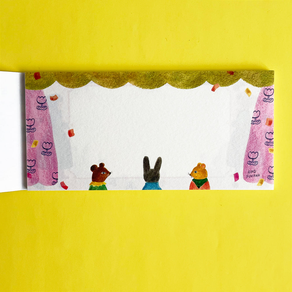 This page of the memo pad features three anthropomorphic animal characters at the bottom of the page, and a green and pink floral curtain framing the writing area.