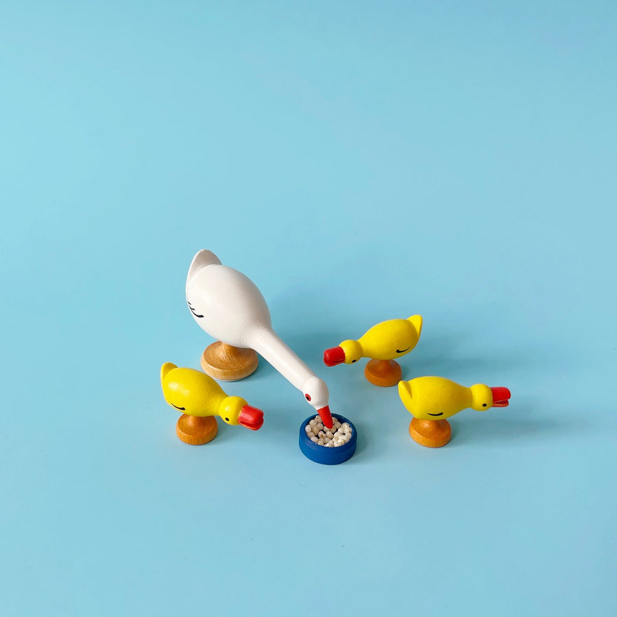 Wooden goose figurines on a blue background. 