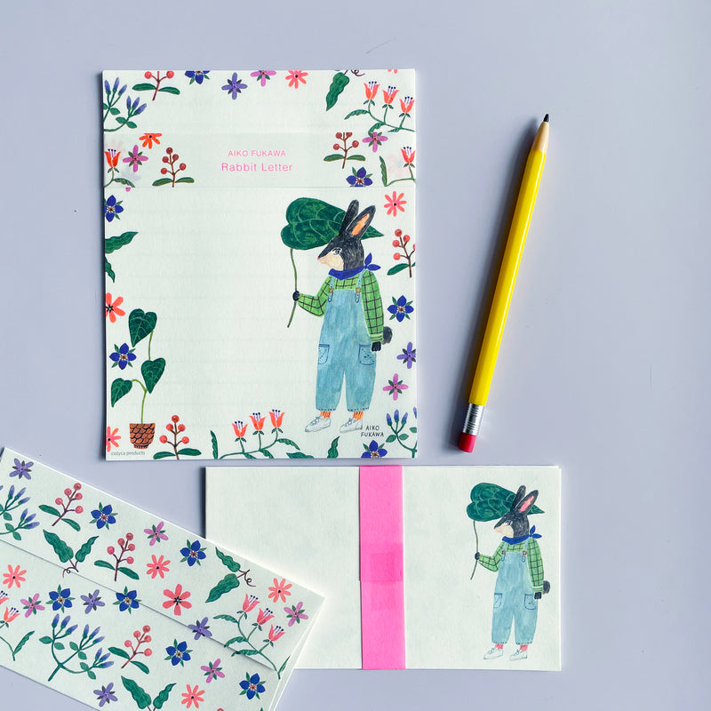 A stationary set illustrated with flowers and a rabbit. A yellow pencil lays on the right. 